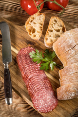 Italian ciabatta bread cut in slices with salami.