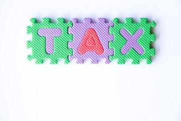 Toy foam alphabet in word tax on white background