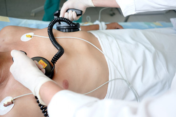 hands of doctor holding defibrillator electrods, performing defibrillation or electropulse therapy