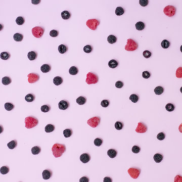 .A lot of tasty colorful berries on a pink background.