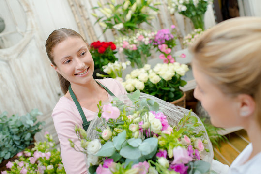 Florist giving lady a flower arrangement