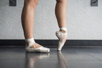 Ballerina warming up her feet in her pointe ballet shoes before class © Katherine BYC