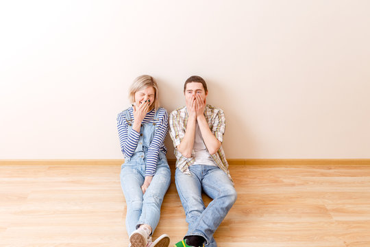 Photo of tired man and woman sitting on floor