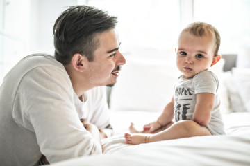 Father and adorable baby on bed