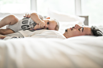Father and adorable baby on bed