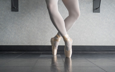 Ballerina dancer in the ballet studio en pointe in releve fourth position  © Katherine BYC