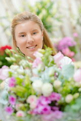 Fototapeta premium Young woman behind a bunch of flowers