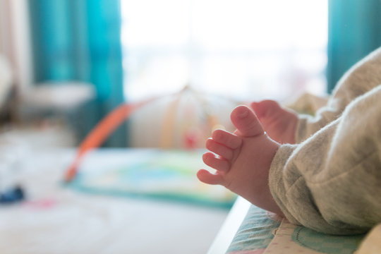 The small tiny cute feet of the infant. Blurred light background. © Jevgenij