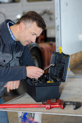 worker picking up a wrench in toolbox