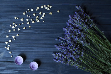 Lavender flowers and wooden love hearts on a dark blue wooden table. Beautiful romantic background with copy space. © Natali Vinokurova