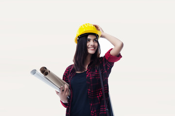 The young woman engineer with yellow safety helmet and hold blueprint in her hand
