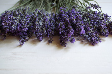 Fresh lavender flowers on a white wooden background.