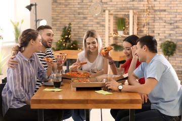 Young people eating pizza at table