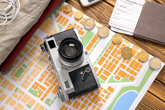 Composition with camera, map and money on wooden background. Travel concept
