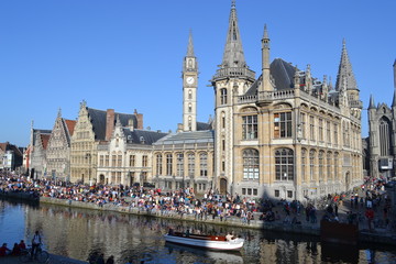 Fototapeta na wymiar Young people, mainly students, relax by the edge of a canal in Ghent, Belgium