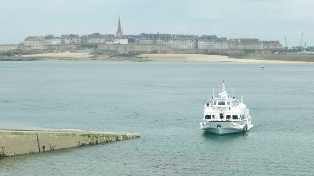 Boat with passengers floats from the city of Saint-Malo to the city of Dinard, France