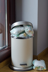 garbage can full of used dirty diapers