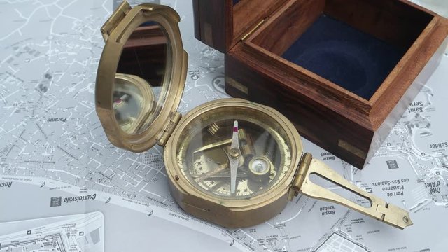 Vintage sea compass with wooden case on the map on the table