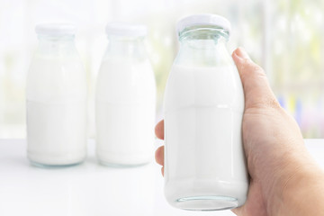 Hand's woman holding a bottle glass of milk isolated on white table background for food and healthy concept.