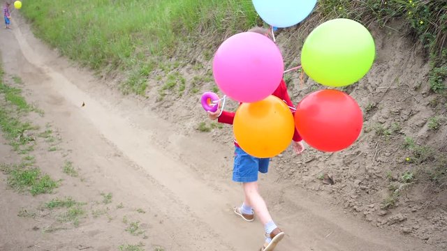 Happy little baby, fun playing with balloons. Outdoor recreation. Celebration and fun.