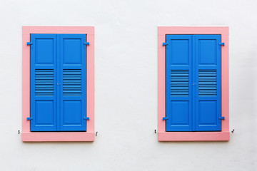 two windows with blue window shutters
