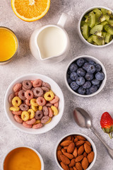 Fototapeta na wymiar Breakfast with colorful cereal rings, fruit, milk, juice.