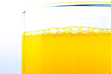 Bubbles of orange soda in a glass closeup macro textured background. Bright view photo.