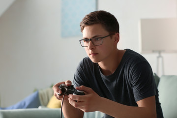 Teenager playing video games at home