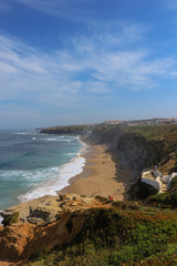 Amazing sandy beach in a summer day, with blue waves. Surf spot in Ericeira Portugal