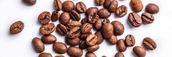 Panoramic background with roasted coffee beans in the middle on a white table