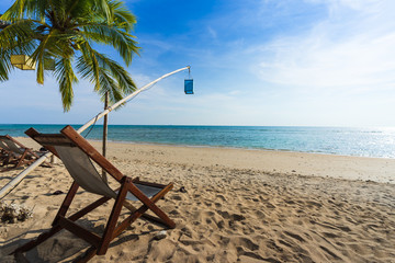 Beach chairs on beautiful tropical island beach with afternoon light.