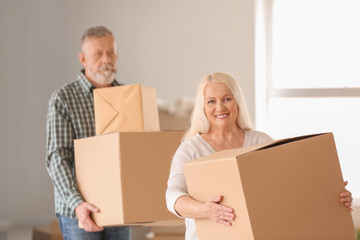 Mature couple with moving boxes at new home