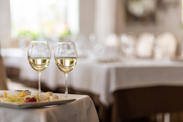 Photo of bottle with pouring champagne in wine glasses on gray background