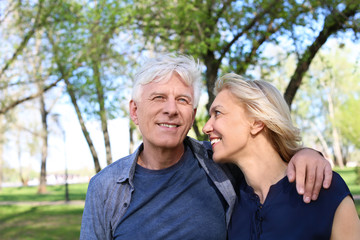 Mature couple resting in park on spring day