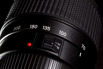 DSLR telephoto zoom lens close up with focus ring measures.