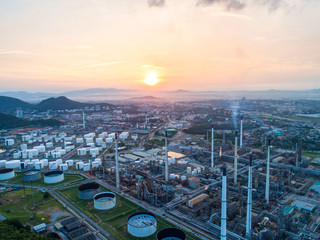 Obraz premium Industrial view at oil refinery plant form industry zone with sunrise and cloudy sky.Oil refinery and Petrochemical plant at dusk,Thailand. Aerial view