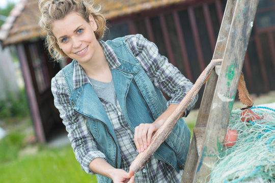 young farm woman posing and leaning on ladder