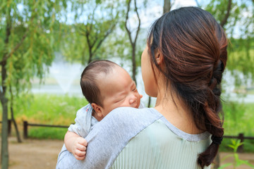 Asian infant nestling in mother's bosom