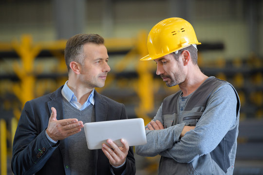 metallurgy workers in workshop using digital tablet