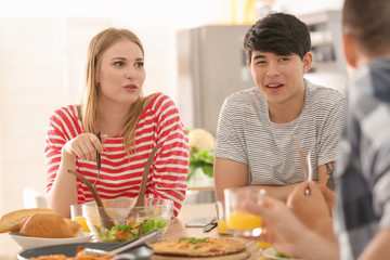 Friends eating at table in kitchen
