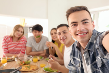 Fototapeta premium Happy friends taking selfie in kitchen
