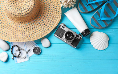 Composition with camera and beach accessories on color wooden background
