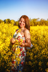 Naklejka na ściany i meble smiling happy girl in yellow rape field