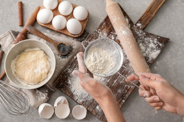 Woman preparing dough on light table