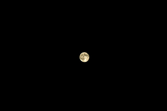 Photo of the moon in the sky on a black background. Soft focus. Isolated on black Minimalism.