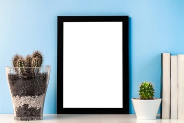 Black frame mockup with cactuses and books on a blue background