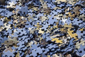 Close-up of a lot of pieces of a bluish jigsaw puzzle.