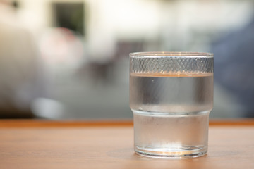Close up of glass of cold water on wooden table.