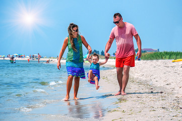 Fototapeta na wymiar young happy family on the beach