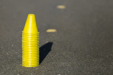 Cones for slalom on roller skates stand on asphalt, inline